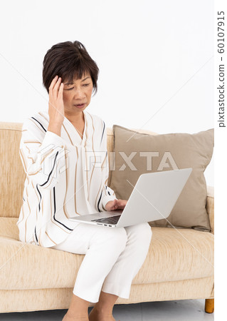 Senior woman worrying about personal computer Senior woman worrying about personal computer 60107915