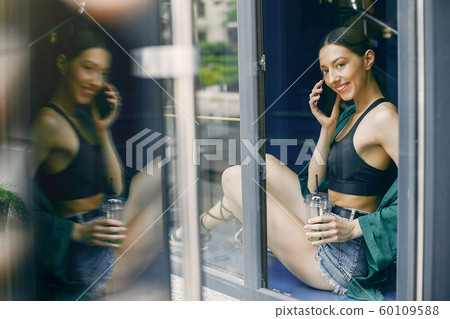 Fashion girl standing in a summer cafe Fashion girl standing in a summer cafe 60109588