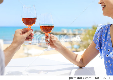 Hands of couple enjoying glasses of rose wine on Hands of couple enjoying glasses of rose wine on 60110795
