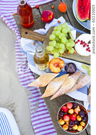 Picnic on the beach at sunset in the style of boho Picnic on the beach at sunset in the style of boho 60110805