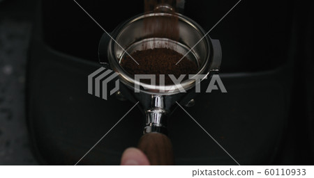 fresh ground coffee falling into portafilter from grinder fresh ground coffee falling into portafilter from grinder 60110933