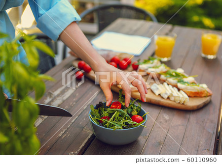 Young woman cooking dinner at the home in the 60110960