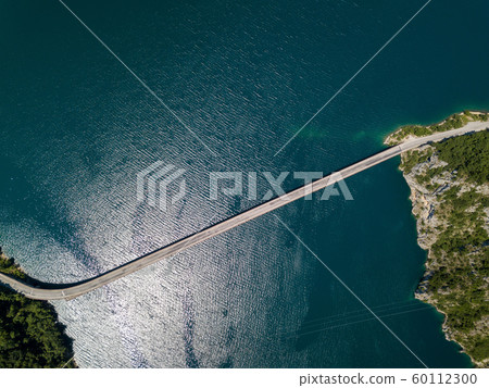 Aerial footage a car driving over a bridge on Piva Lake 60112300