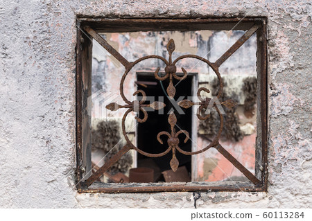 Grid in a fence of an abandoned house Grid in a fence of an abandoned house 60113284