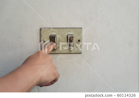 Hand turning the old electrical switches off. Hand turning the old electrical switches off. 60114326