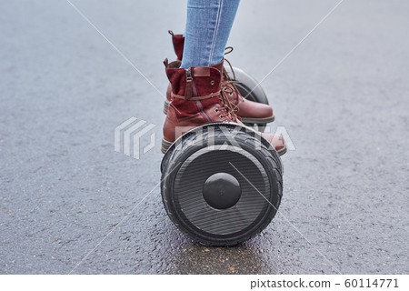 Close up of woman using hoverboard on asphalt Close up of woman using hoverboard on asphalt 60114771
