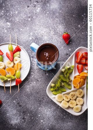 Sweet chocolate fondue with fruits Sweet chocolate fondue with fruits 60115734
