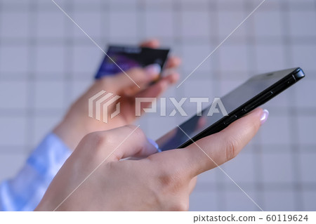 Woman using smartphone and credit card for online shopping 60119624