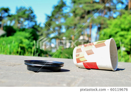 Discarded coffee cup in on ground.  60119676