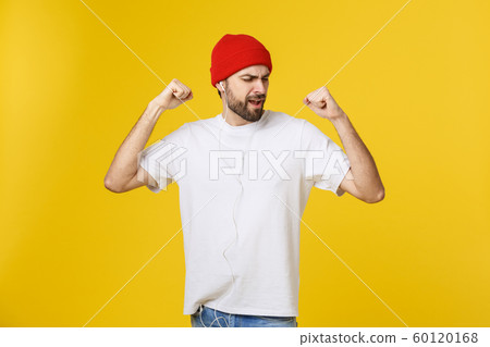Portrait of a handsome young man dancing and listening music, isolated on yellow background Portrait of a handsome young man dancing and listening music, isolated on yellow background 60120168