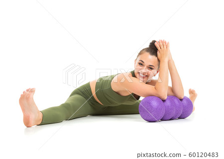 attractive brunette girl in a green sports suit goes in for sports with a simulator on a white attractive brunette girl in a green sports suit goes in for sports with a simulator on a white 60120483