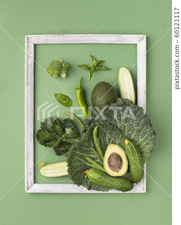 Green composition of fresh organic vegetables inside wooden frame 60121117