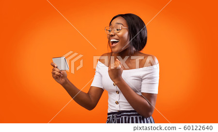 Happy Afro Girl Holding Cellphone Gesturing Yes, Orange Background, Panorama 60122640