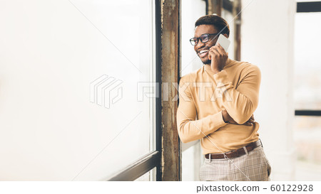 Smiling african american guy talking on cell phone Smiling african american guy talking on cell phone 60122928