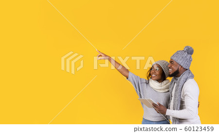 Interested girl showing her man advertisement, pointing at free space 60123459