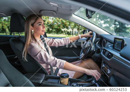 Beautiful girl business lady summer city car. Reversing, looking rearview mirror, engaging reverse gear, traffic jam parking lot. Car rental, car sharing. Automatic transmission. Autumn day nature. 60124253