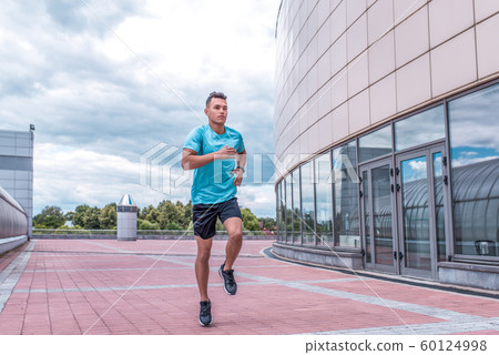 Athletic man running in jump in training, runner in sportswear, training in city during summer, active lifestyle, modern fitness workout. Free space for motivation text. Athletic man running in jump in training, runner in sportswear, training in city during summer, active lifestyle, modern fitness workout. Free space for motivation text. 60124998