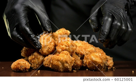 Cool beautiful fresh juicy cooked chicken wings in breading. Buffalo wings spread on food in white plate. Cooking with deep fryer fry machine. Cool beautiful fresh juicy cooked chicken wings in breading. Buffalo wings spread on food in white plate. Cooking with deep fryer fry machine. 60125001