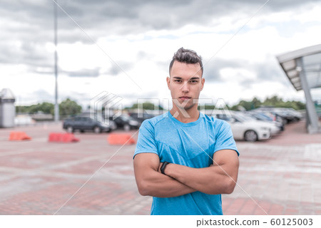 sporty man stands confidently, trainer poses, courageous look confident and strong, training in city during summer, an active lifestyle, modern fitness workout. Free space for motivation text. sporty man stands confidently, trainer poses, courageous look confident and strong, training in city during summer, an active lifestyle, modern fitness workout. Free space for motivation text. 60125003