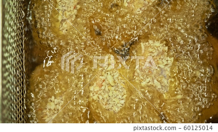 Fast food. Deep fryer with boiling oil and chicken. Large, deeps fryed container for frying food freshly baked Buffalo wings. Fast food. Deep fryer with boiling oil and chicken. Large, deeps fryed container for frying food freshly baked Buffalo wings. 60125014