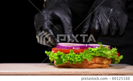 Craft burger is cooking. Consist: red sauce salsa, lettuce, red onion, pickle, cheese, chilli green pepper, air bun and marbled meat beef. 60125188