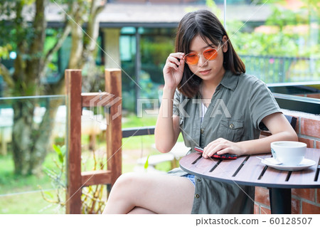 woman sitting in a cafe terrace woman sitting in a cafe terrace 60128507