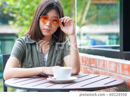 woman sitting in a cafe terrace woman sitting in a cafe terrace 60128508