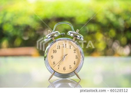 Silver alarm clock on table Silver alarm clock on table 60128512