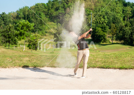 Profession asian Golfer hitting out of a sand trap. 60128817
