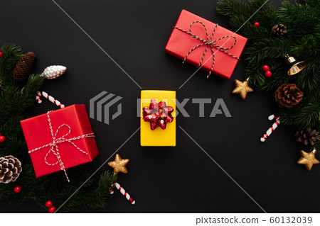 Christmas gift box and pine tree with xmas decoration on black background Christmas gift box and pine tree with xmas decoration on black background 60132039