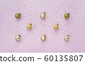 Creative pattern with golden balls and star confetti on pink pastel background top view. 60135807