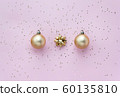 Golden christmas balls, golden bows and star confetti on pink pastel background top view. Flat lay 60135810