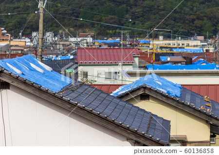 有藍色板料的損壞的房子在屋頂 有藍色板料的損壞的房子在屋頂 60136858