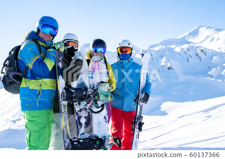 Photo of four athletes wearing helmet and holding snowboards at snow resort . Photo of four athletes wearing helmet and holding snowboards at snow resort . 60137366