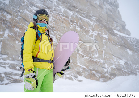 Sports woman in helmet and glasses with snowboard at ski resort . Sports woman in helmet and glasses with snowboard at ski resort . 60137373