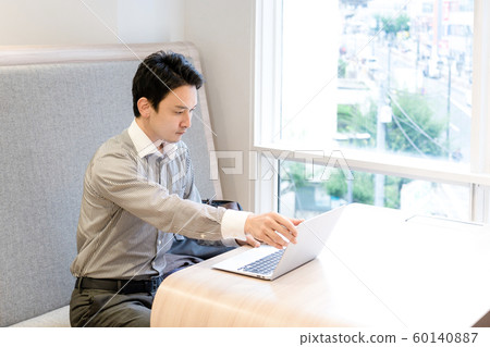 商人在咖啡館裡打開筆記本電腦 60140887