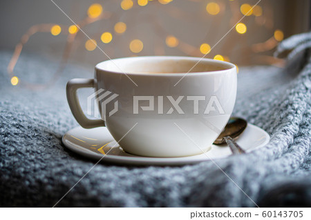 Cup of coffee with milk on cozy knitted winter blanket Cup of coffee with milk on cozy knitted winter blanket 60143705