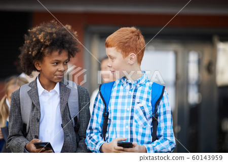 Two schoolboys with mobile phones Two schoolboys with mobile phones 60143959