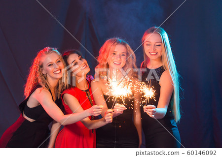 Birthday party, new year and holidays concept - Group of female friends celebrating holding sparklers Birthday party, new year and holidays concept - Group of female friends celebrating holding sparklers 60146092
