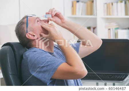 Man applying eye drops 60146487