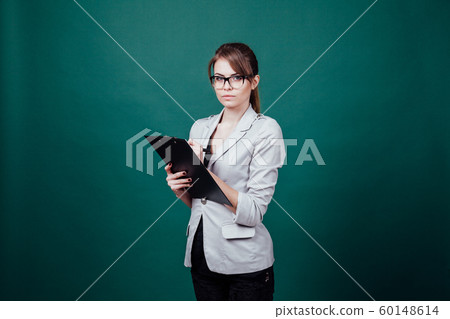 teacher in a business suit stands at green board 60148614