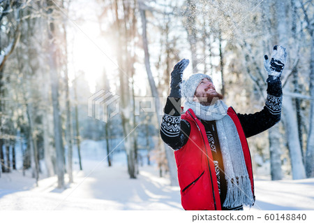 Young man having fun in snow outdoors in winter. Copy space. 60148840