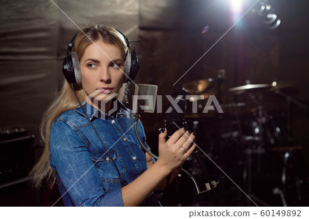 Female singing a sing at recording studio. Female singing a sing at recording studio. 60149892