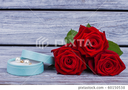 Red roses and box with pearl earrings. 60150538