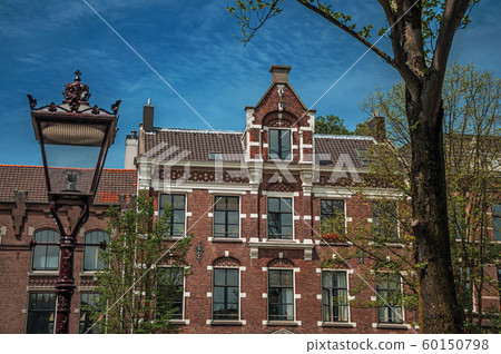 Light post and old brick building facade in Amsterdam 60150798