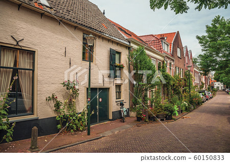 Alleyway with brick houses and flowered pots in Gouda Alleyway with brick houses and flowered pots in Gouda 60150833