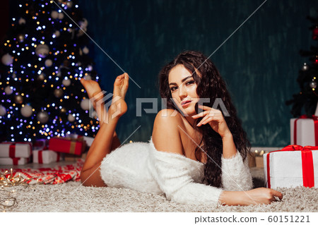beautiful woman at the Christmas tree with gifts of decor for the new year beautiful woman at the Christmas tree with gifts of decor for the new year 60151221