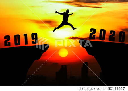 Silhouette young man jumping from 2019 to 2020 Silhouette young man jumping from 2019 to 2020 60151627