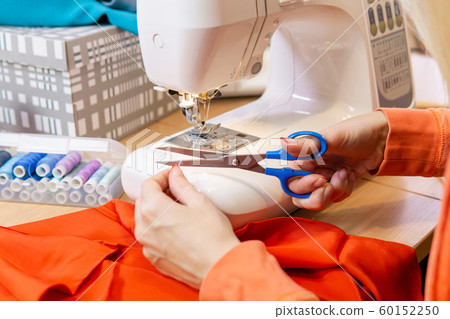 seamstress cuts the sewing machine thread, seamstress cuts the sewing machine thread, 60152250
