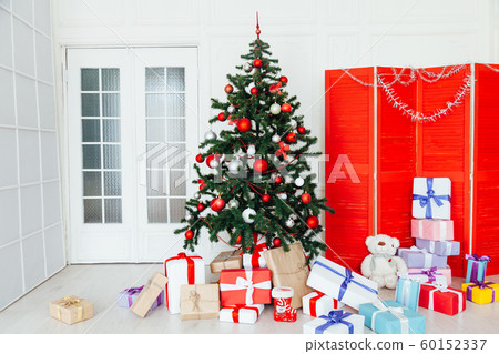 Christmas tree with red gifts December decor in the interior of the white room as a background 60152337